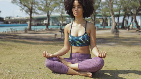 Relaxed-meditating-woman-on-green-lawn