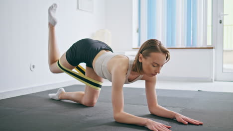 mujer empoderada doblando las piernas practicando gimnasia en casa. mujer estirando el cuerpo