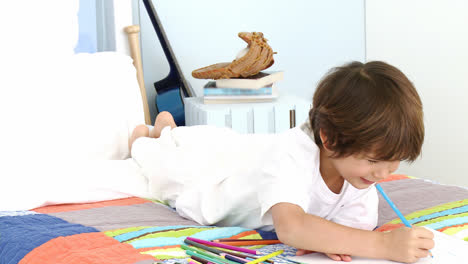 Smiling-little-boy-drawing-in-bed