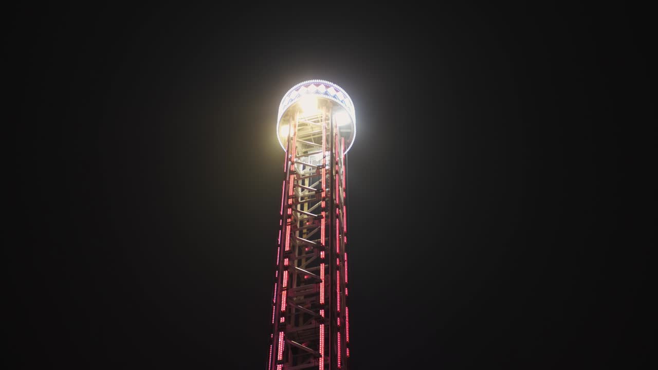 el paseo por la torre en el parque de atracciones nocturno