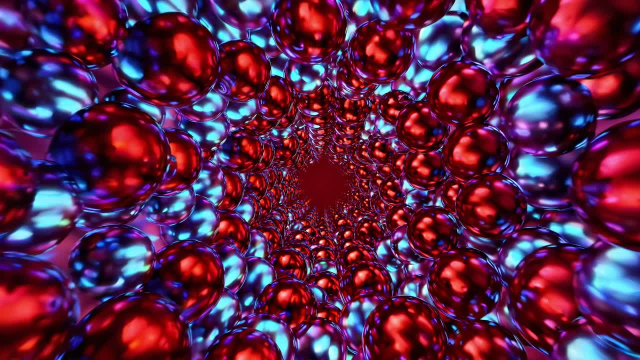 Metallic balls form a tunnel, their surfaces reflecting light in a mesmerizing display as the colors gradually shift from cool blues and purples to warm reds and pinks