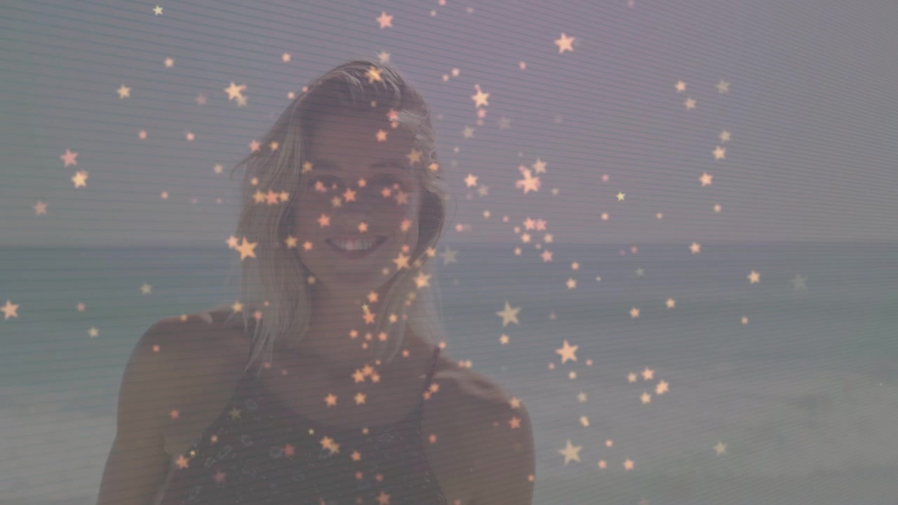 Vídeo vertical: Câmera filmando mulher de maiô posando, inclinando a cabeça, balançando no mar, sobreposição de estrelas