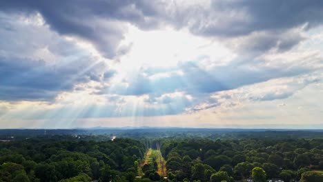 beautiful and perfect cinematic drone shot showing rays of sun streaking through storm clouds in greenville, sc. shining on the duke power lines...hope after hurricane helene for power...