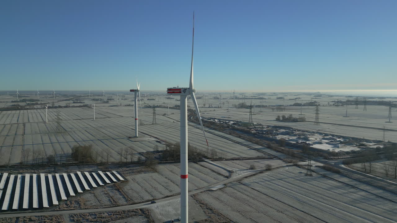 서리가 내린 풍경, 밝은 푸른 하늘, 천천히 움직이는 공중 드론 샷에서 회전하는 풍력 터빈