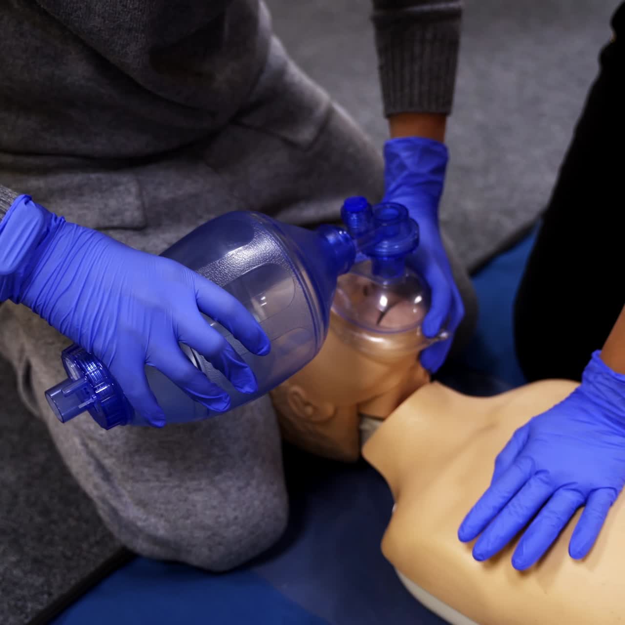 Saving patient's life on a dummy. Students practice medical learning on a mannequin. Medical training course for resuscitation.