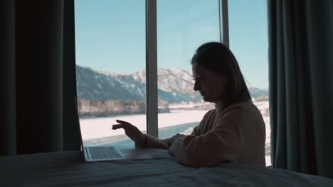 tired woman working from home sitting in the bedroom by the window