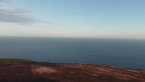 sunrise of bristol channel showing wales in distance from holdstone down north devon uk with panning aerial drone shot 4k