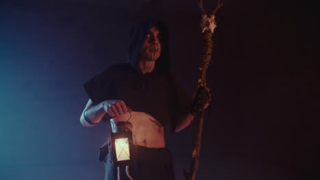 dark figure with lantern and staff