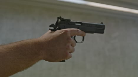 Shooter-dry-firing-small-caliber-pistol-on-interior-shooting-range