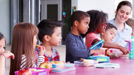 Niños-De-Escuela-Primaria-Comiendo-En-La-Mesa-Con-Almuerzos-Para-Llevar.