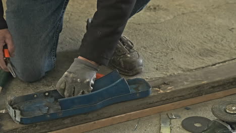 primer plano de un trabajador calificado que trabaja en una pieza de metal con alicates en un taller industrial - cámara lenta, tiro estático