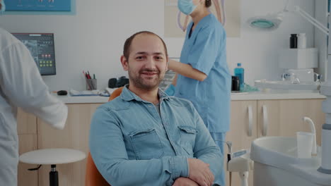 portrait of patient sitting in dental chair at oral care clinic