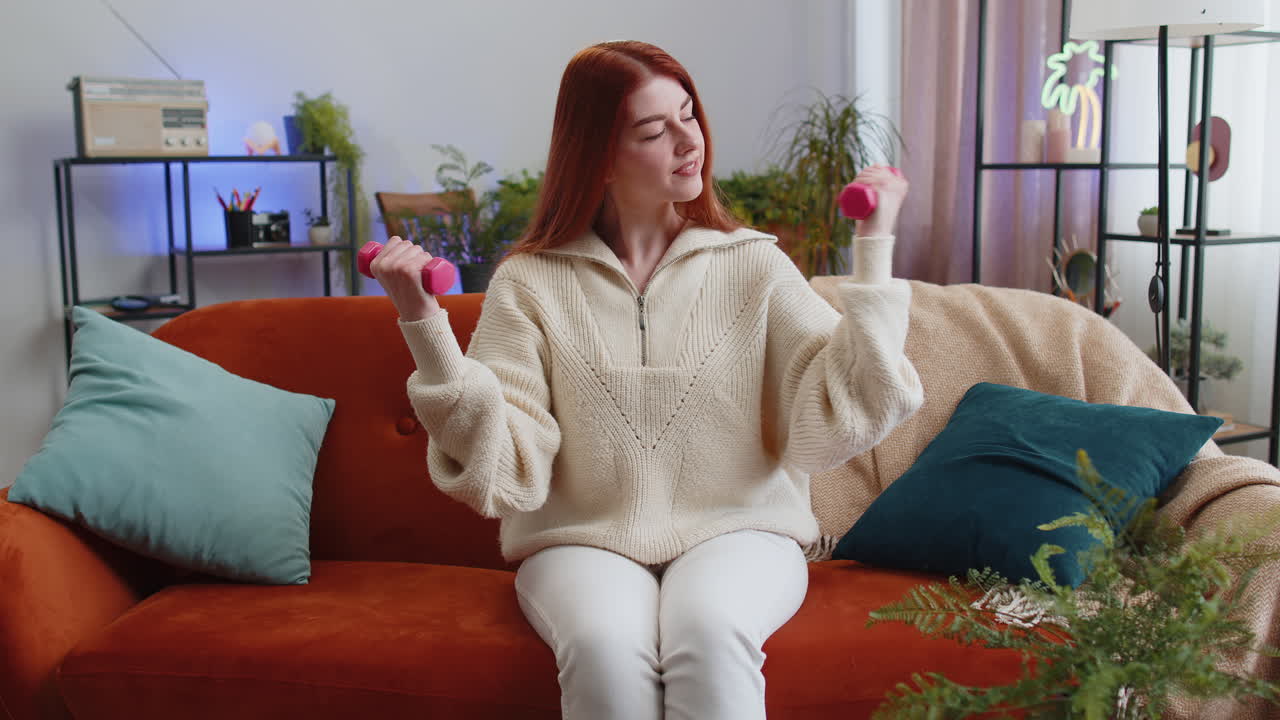 Woman do dumbbells weight lifting biceps excersices at home burning fat calories training strength