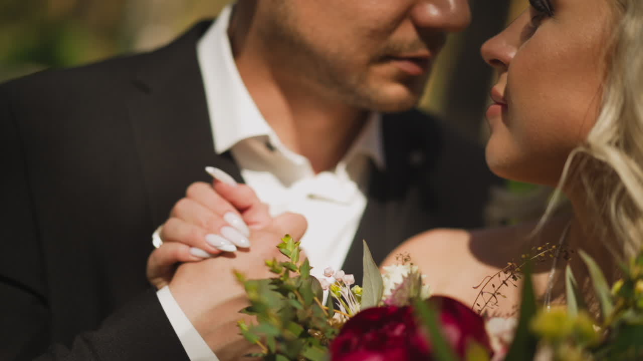 una pareja de damas con un ramo y un hombre de manos en el parque