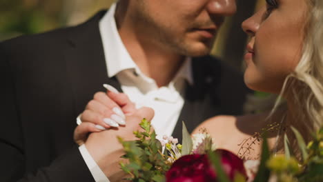 una pareja de damas con un ramo y un hombre de manos en el parque