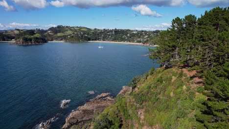 distant view of palm beach coastal settlement on waiheke island, new zealand