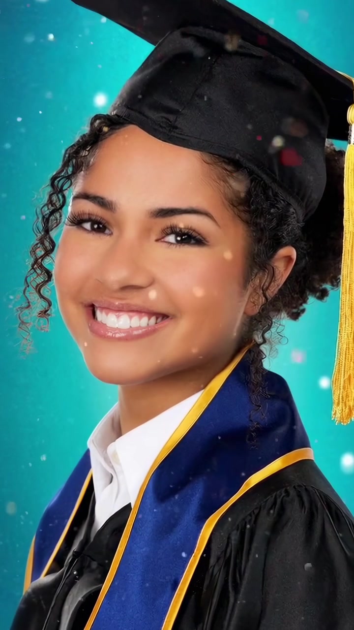Giovane donna sorridente con tocco e toga di laurea