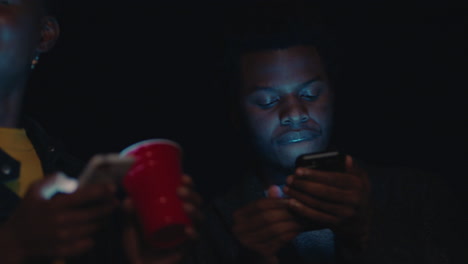 group-of-friends-relaxing-on-rooftop-at-night-using-smartphone-technology-texting-sharing-social-media-lifestyle-browsing-online-enjoying-weekend-party