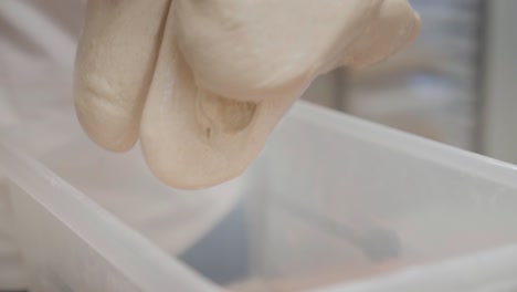 kneading dough in slow motion, close up view on hands