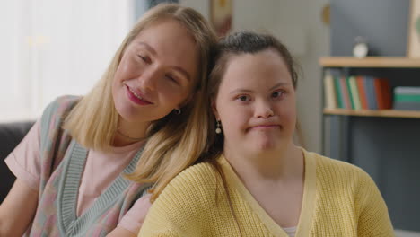 portrait of happy woman and girl with down syndrome at home
