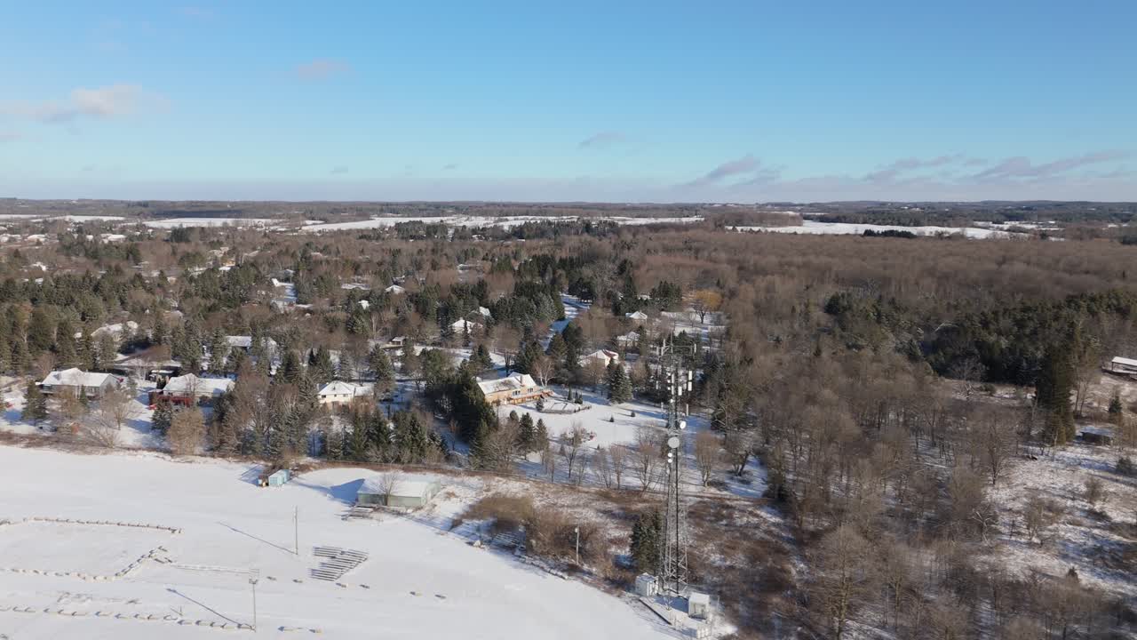 집, 나무, 그리고 보이는 전화탑이 있는 칼레돈 마을의 눈 인 공중 풍경