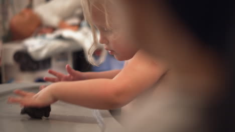 little kid learning to make playdough things