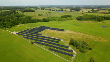 aerial drone flight over beautiful green landscape and modern solar panel farm - production of renewable and environmental energy