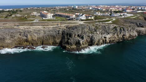 Felsige-Küste-Mit-Ruhigen-Meereswellen,-Die-Auf-Felsen-Und-Häuser-Neben-Der-Küste-Treffen