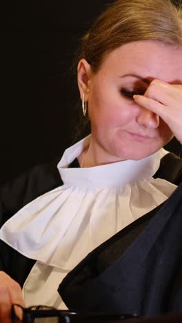 focused female judge working on laptop in courtroom, showing expressions of concentration and authority. vertical video