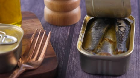 canned sardines on a wooden board