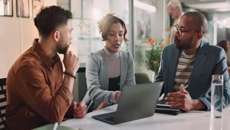 business team discussing project on laptop