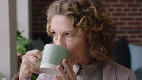 portrait mature caucasian woman drinking coffee at home looking out window planning ahead thinking successful middle aged female contemplating retirement