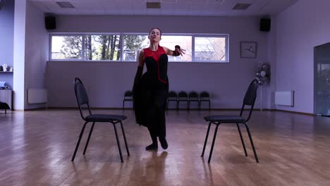 professional female dancer dances around two chairs