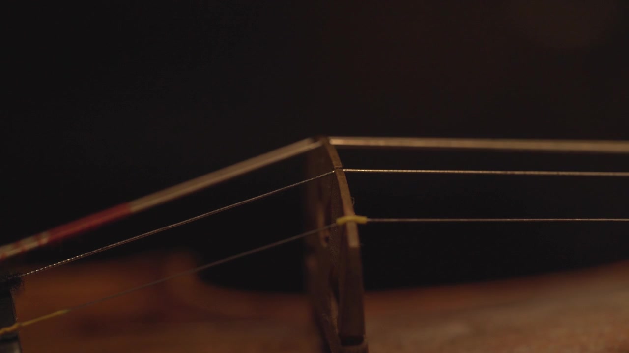 primo piano del vecchio violino, drammatici cambiamenti di luce sullo strumento, riprese video di musica sinfonica classica