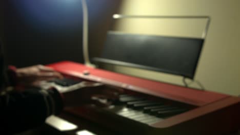 toma borrosa de un pianista experto tocando un piano eléctrico rojo en esta impresionante actuación en solitario