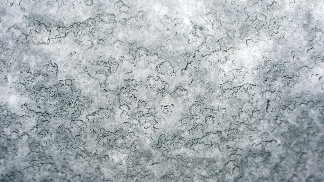 Primo piano di una superficie ghiacciata o satinata con texture fine e tenui tonalità di blu