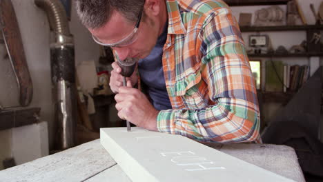 stone mason at work on carving in studio shot on red camera