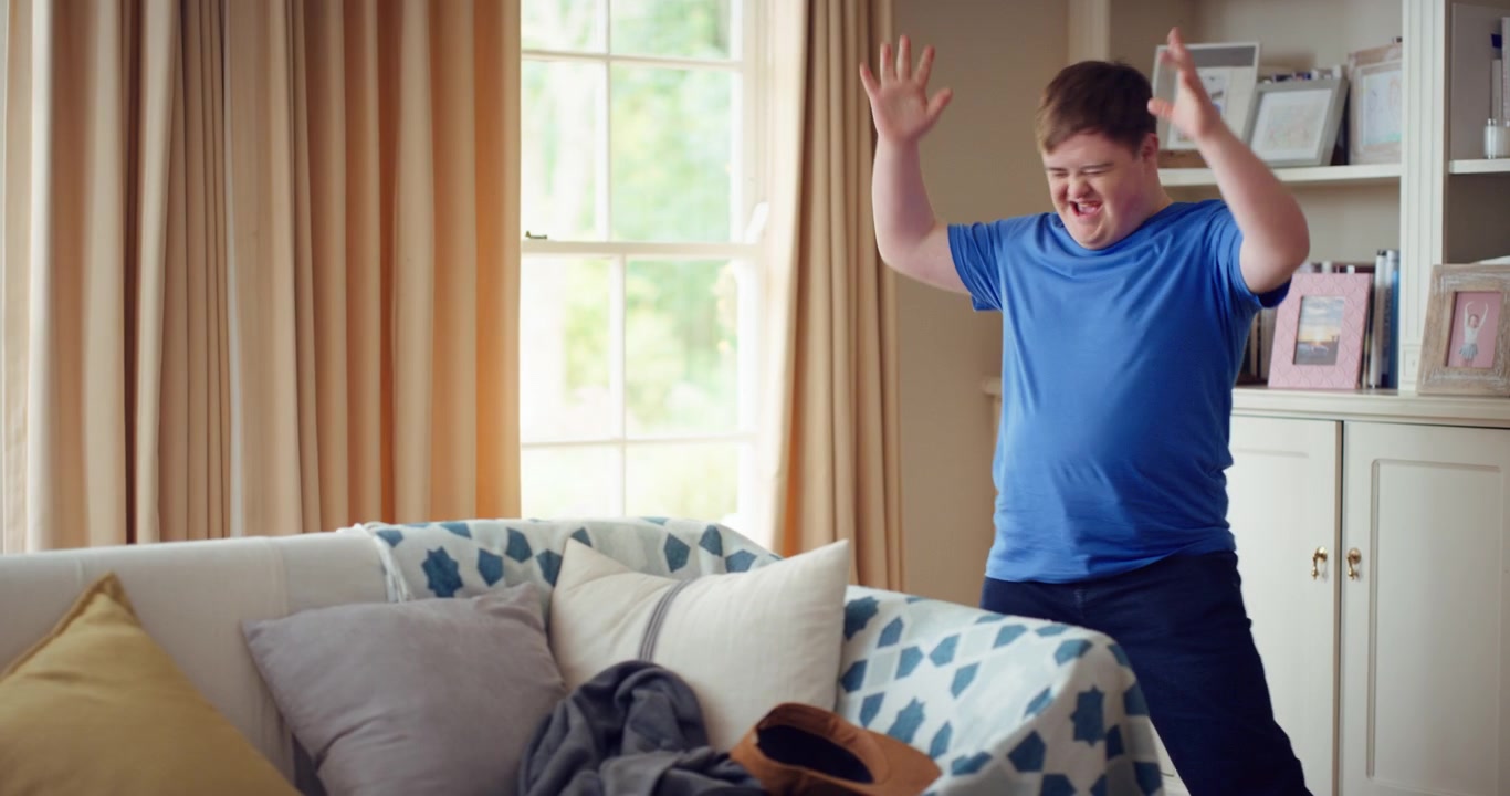 Young Man with Down Syndrome Dancing Energetically in Living Room