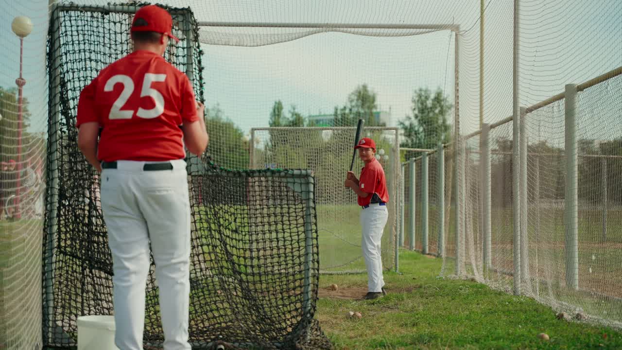 Giocatori di baseball che si allenano nella gabbia di battuta