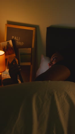 woman in bed using a phone at night