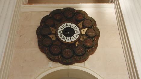 ornate wooden clock above stairway hall in tskaltubo spa, georgia