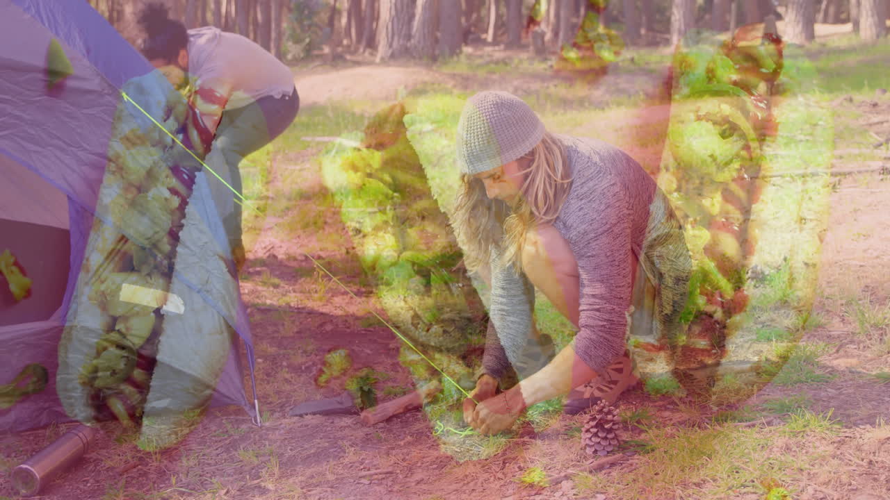 People setting up tent in forest with green foliage animation overlay