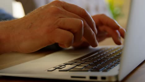 Close-up-of-active-senior-man-using-laptop-at-home-4k