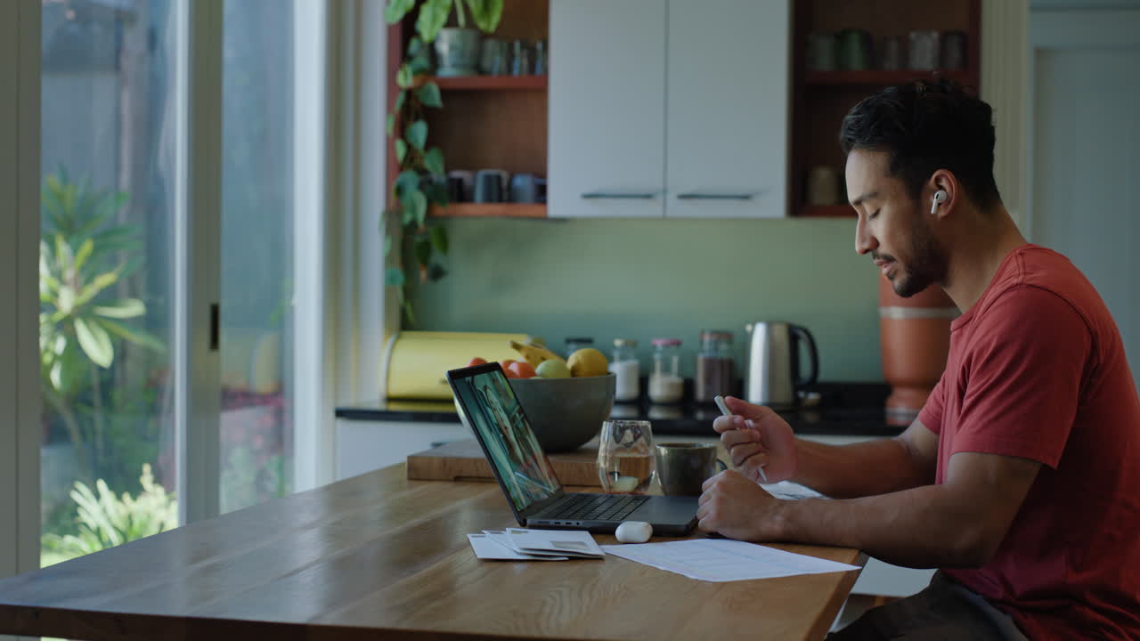 trabajo remoto, portátil y hombre en la cocina en video