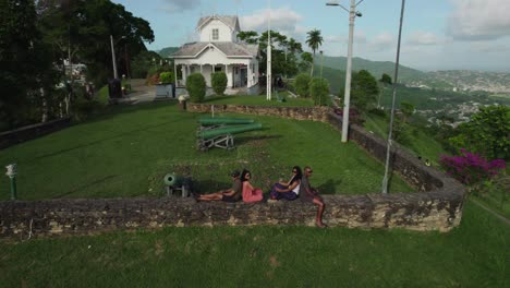 aerial view of friends sittting on a wall at fort george, port of spain trinidad