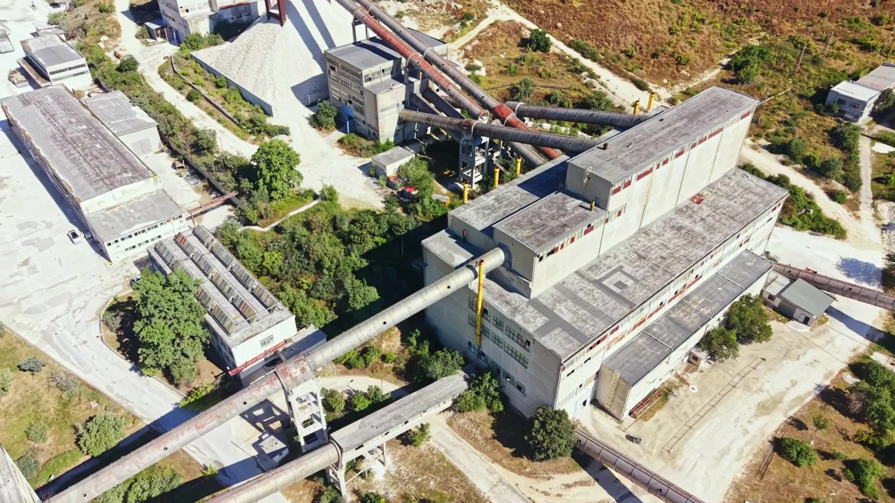 Quarry site with production facilities and transportation systems in operation during daytime