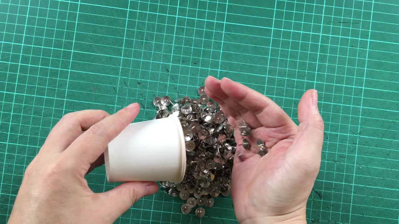 la mano vertiendo pinzas en la alfombra de corte