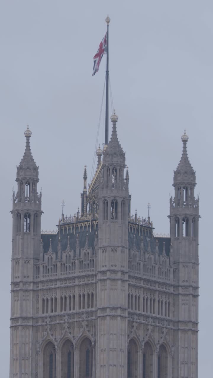 Iconic London tower with Union Flag, vertical view, overcast mood
