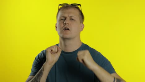 portrait of young caucasian man posing in green t-shirt. happy handsome guy celebrates and dances