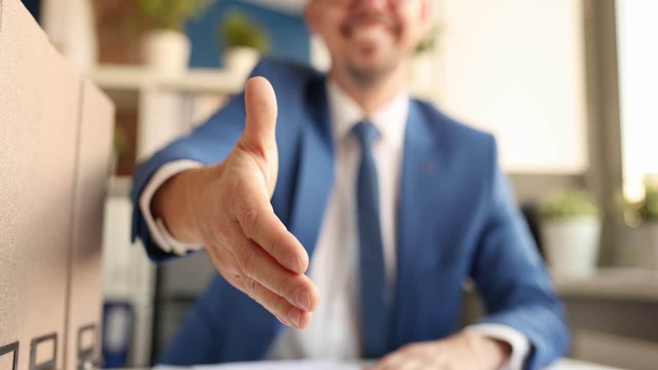 Joven empresario sonriente extendiendo su mano para un apretón (video 4K)